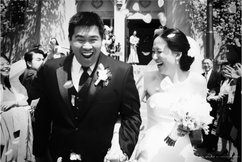 bride and groom with tossed rose petals